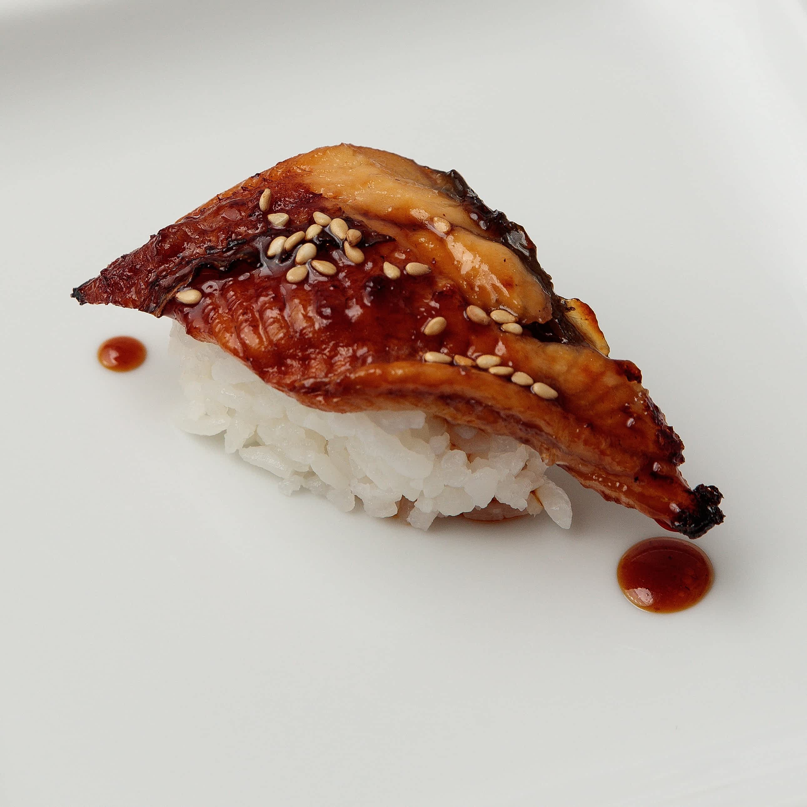 Single piece of Unagi nigiri with sesame seeds